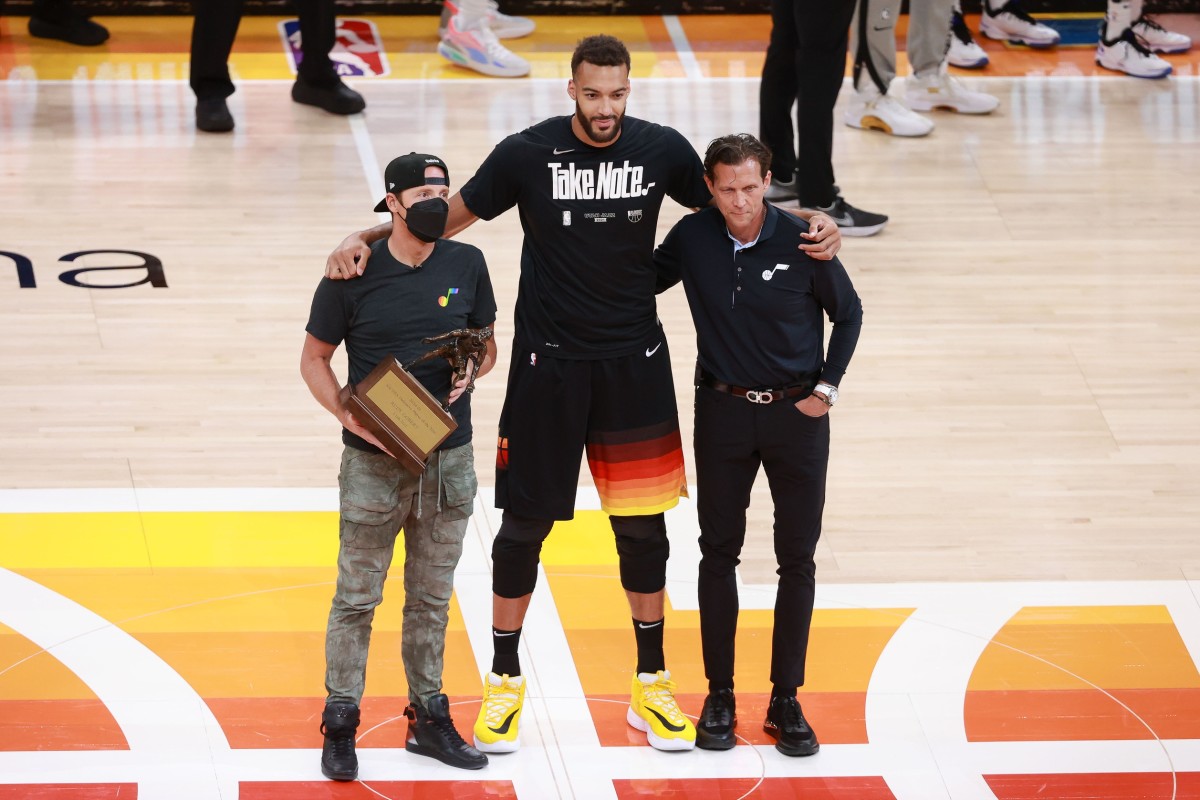 Rudy Gobert (center) is awarded the Defensive Player of the Year Award by Jazz Owner Ryan Smith (left) and Head Coach Quin Snyder (right)